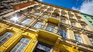 A multi-story building with ornate architectural details, including a balcony and a sign indicating the hotel's name. - Wenceslas Square Hotel - Czech Leading Hotels (Prague)