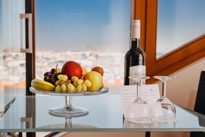 Uma mesa com uma tábua de frutas, uma garrafa de vinho e copos de vinho.