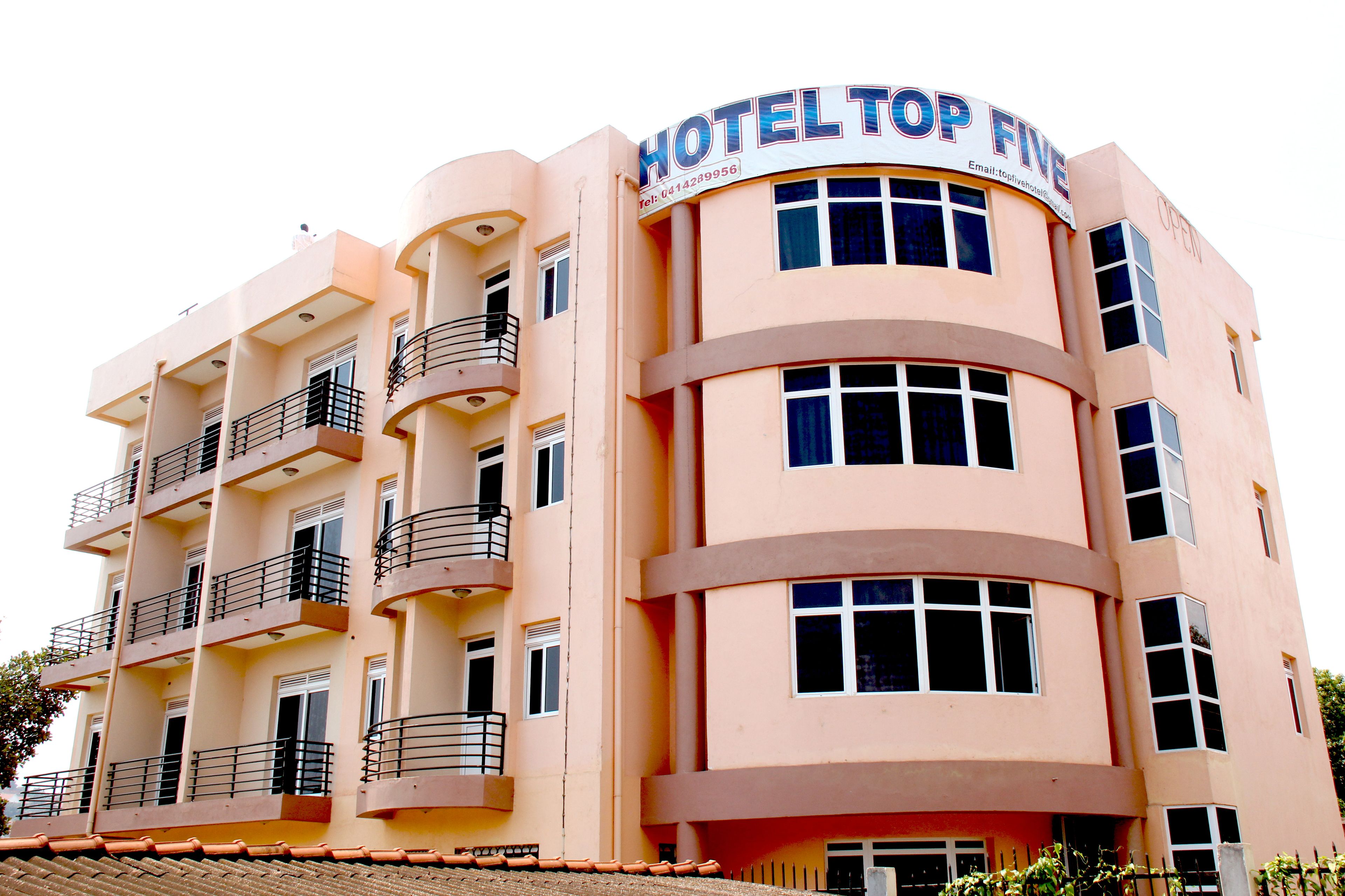 A multi-story hotel with balconies, a prominent sign reading "HOTEL TOP FIVE," and a curved facade.