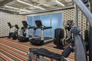 A gym with treadmills, elliptical machines, and weight equipment.