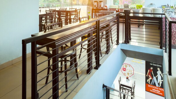 Una cafetería con mostrador, zona de estar y una escalera.