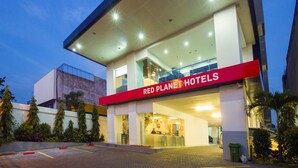 Un hotel con un cartel rojo llamativo que dice 'RED PLANET HOTELS'.