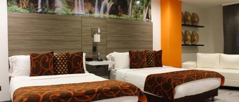 Habitación de hotel con dos camas, un mural grande de una cascada, una lámpara moderna y un sofá blanco.