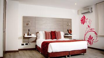 A modern bedroom with a large bed, a bedside table, a wall-mounted shelf, and an air conditioning unit.