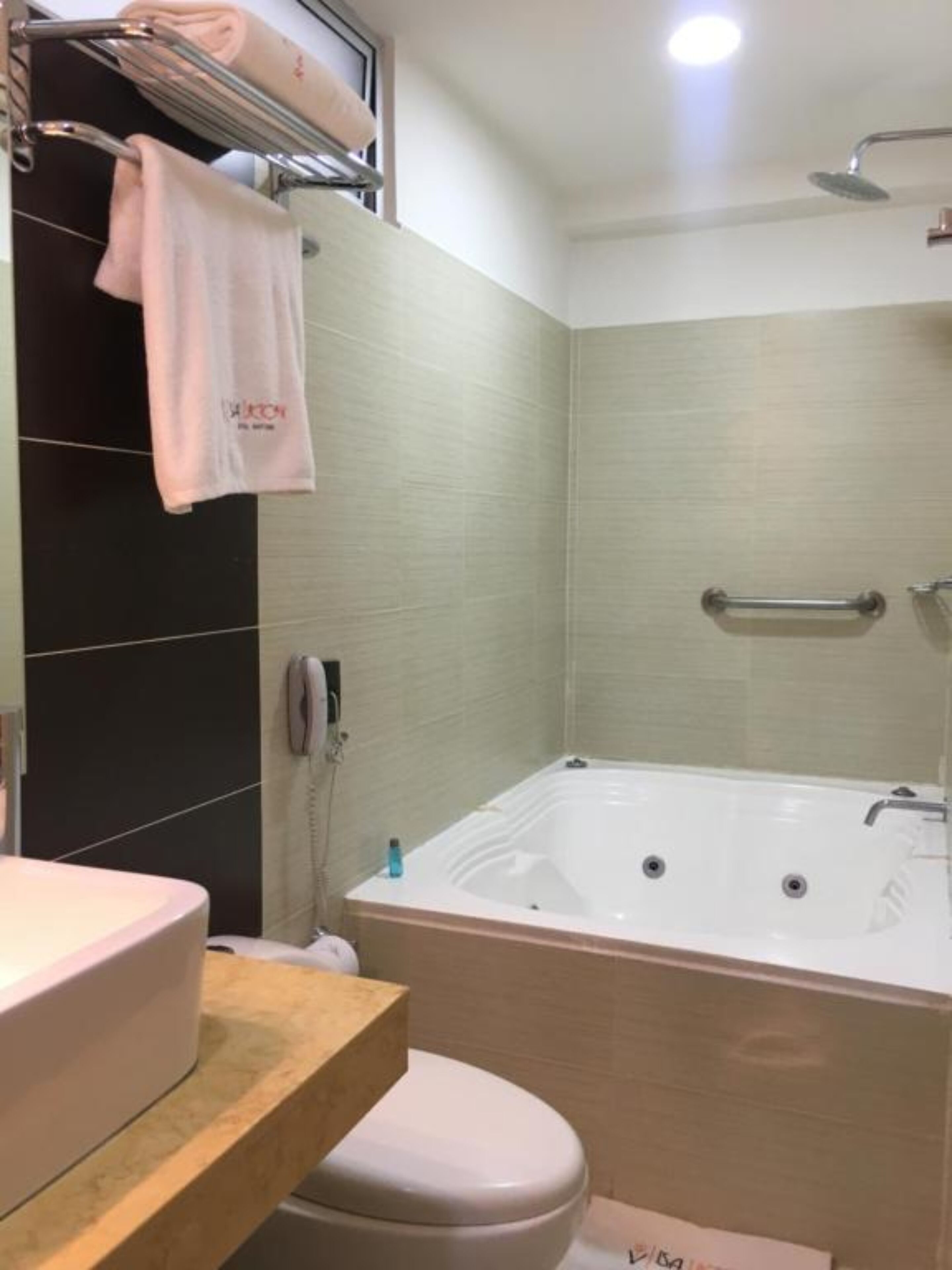 A bathroom with a bathtub, a toilet, a sink, and a towel rack.