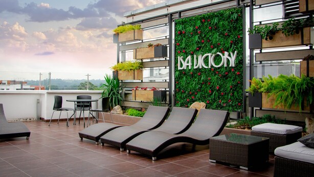 A rooftop terrace with lounge chairs, a table, and a vertical garden wall with the name "DA LUCIOY". - Isa Victory Hotel Boutique (Armenia)