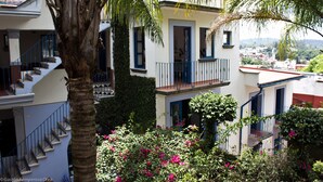 Un edificio de varios pisos con balcones, una escalera y vistas a un pueblo.
