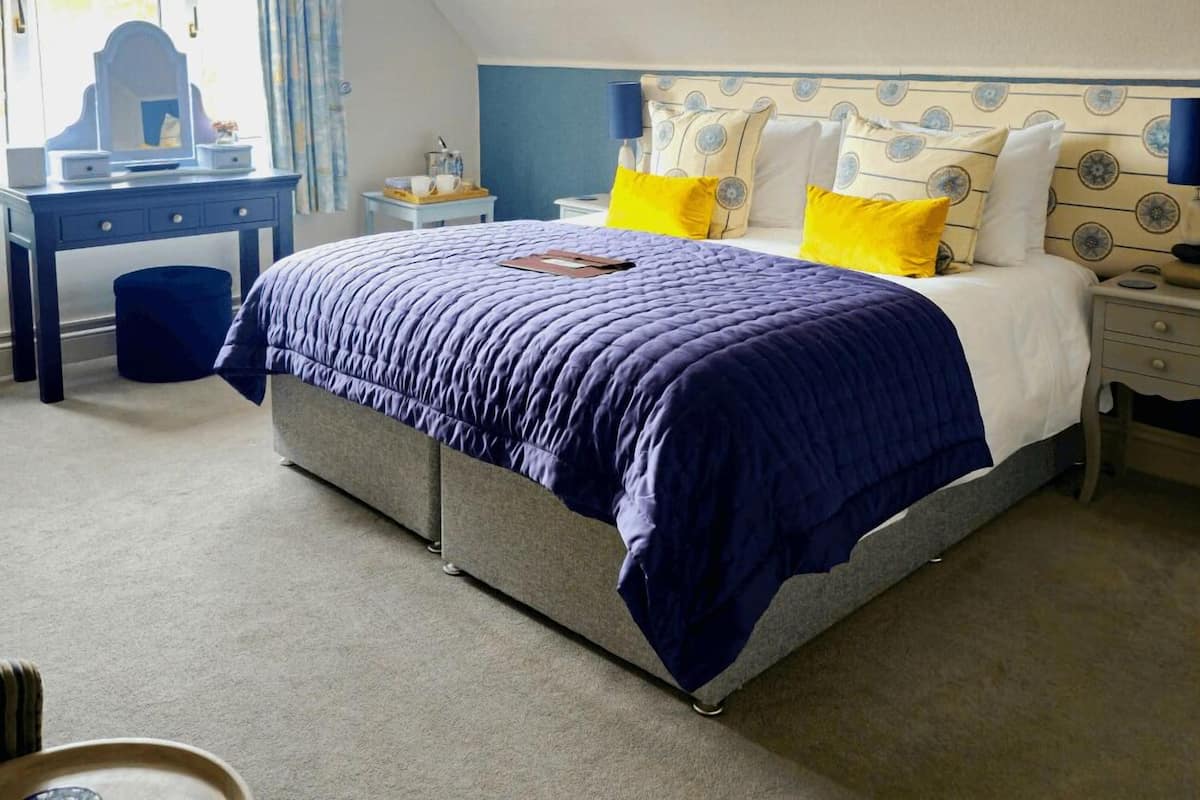 A bedroom with a bed, bedside tables, a desk, and a chair.