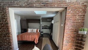 A compact, open-plan living space with a bed, sofa, and kitchenette. - The Olde Mill Inn Bed & Breakfast (Cumberland Gap)
