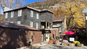 A two-story building with a sloped roof, a brick section, and a sign indicating a studio apartment. - The Olde Mill Inn Bed & Breakfast (Cumberland Gap)