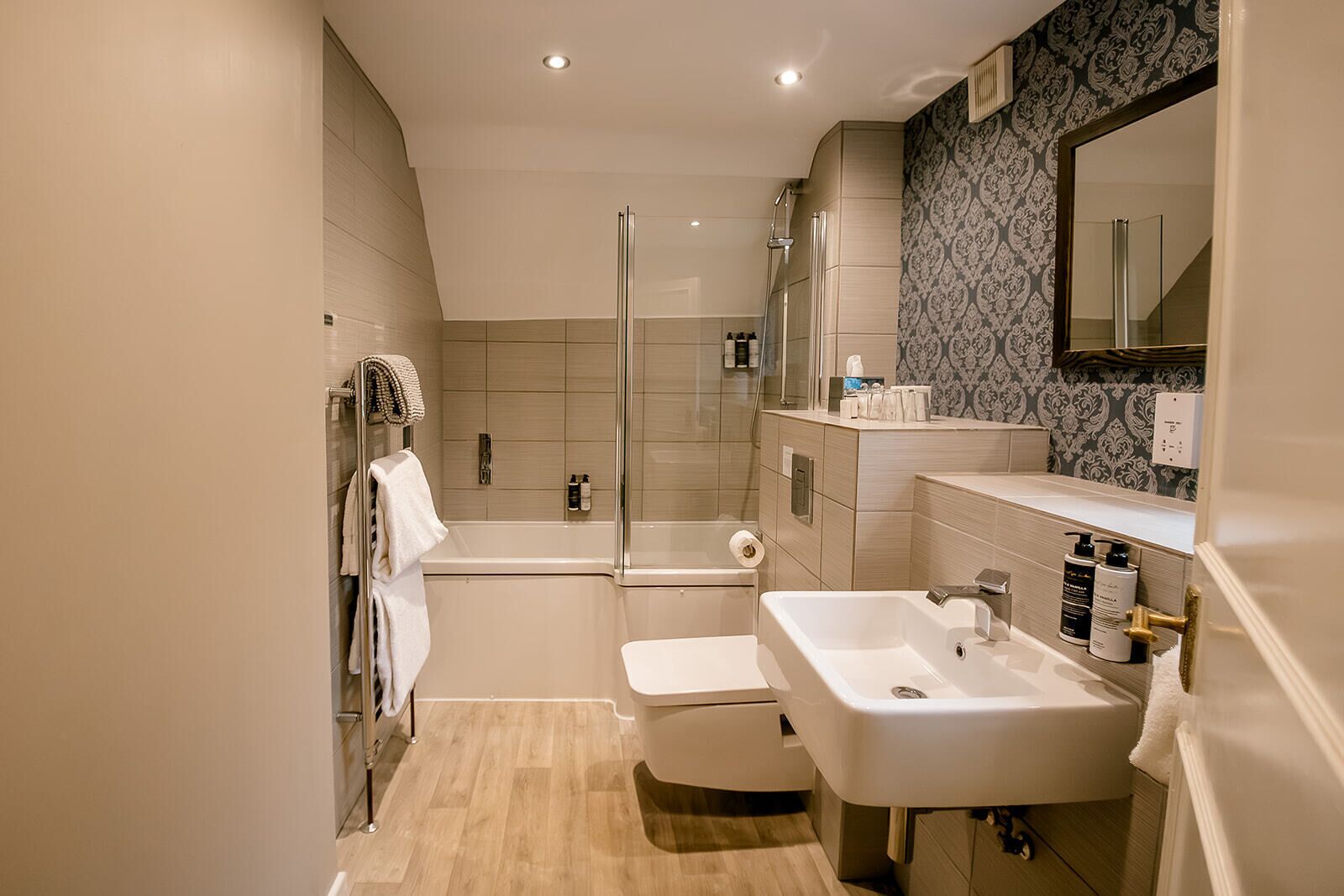 A modern bathroom with a shower, toilet, and sink.