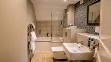 A modern bathroom with a shower, toilet, and sink.