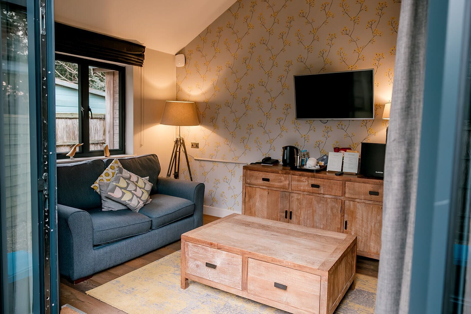 Un salon comprenant un canapé, une table basse, un meuble en bois et un téléviseur à écran plat.