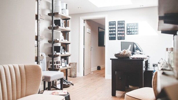 A modern living room with a sofa, a coffee table, and a bookshelf. There is a door leading to another room. - Norfolk Mead (Norwich)