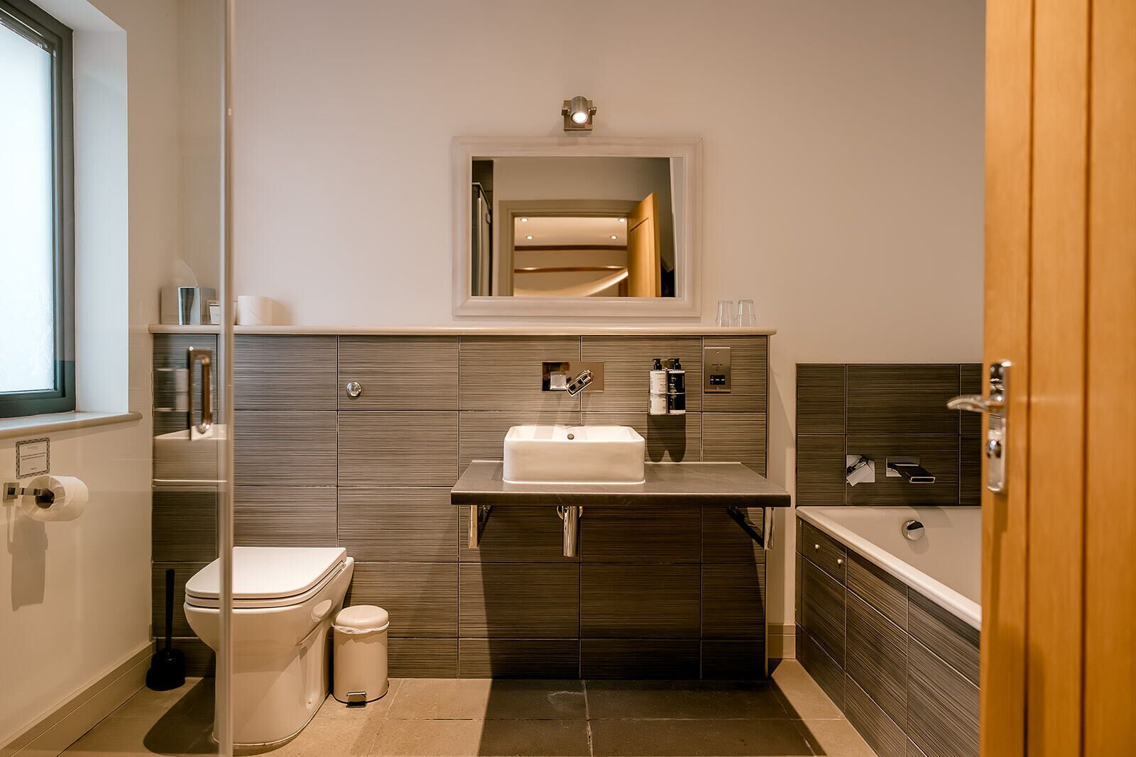 Un baño moderno con inodoro, lavabo y bañera.
