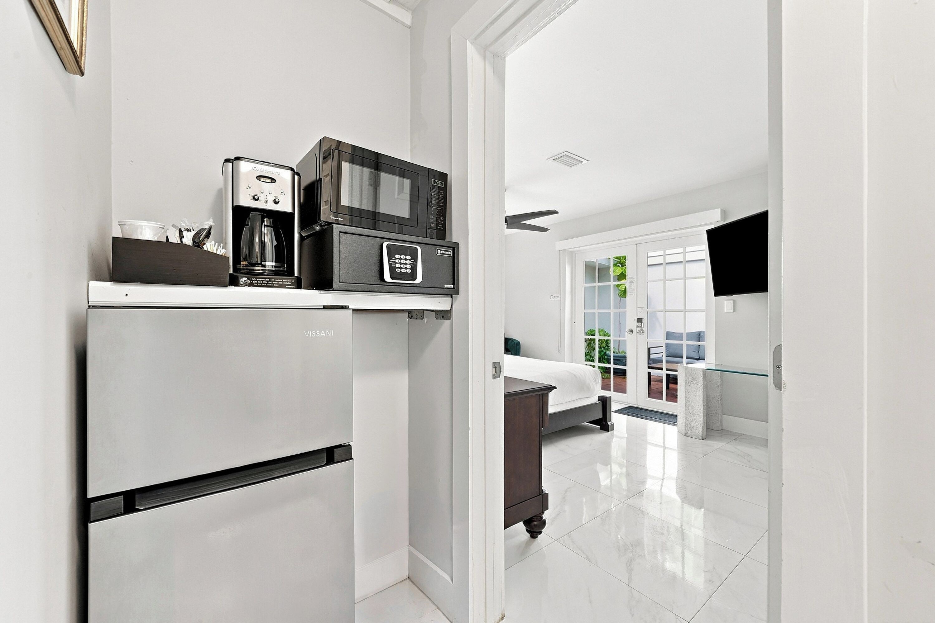 A modern kitchen with a built-in refrigerator, a coffee maker, and a microwave.
