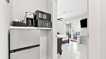A modern kitchen with a built-in refrigerator, a coffee maker, and a microwave.