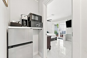 A modern kitchen with a built-in refrigerator, a coffee maker, and a microwave. - Inn On The Drive (Adults Only) (Wilton Manors)