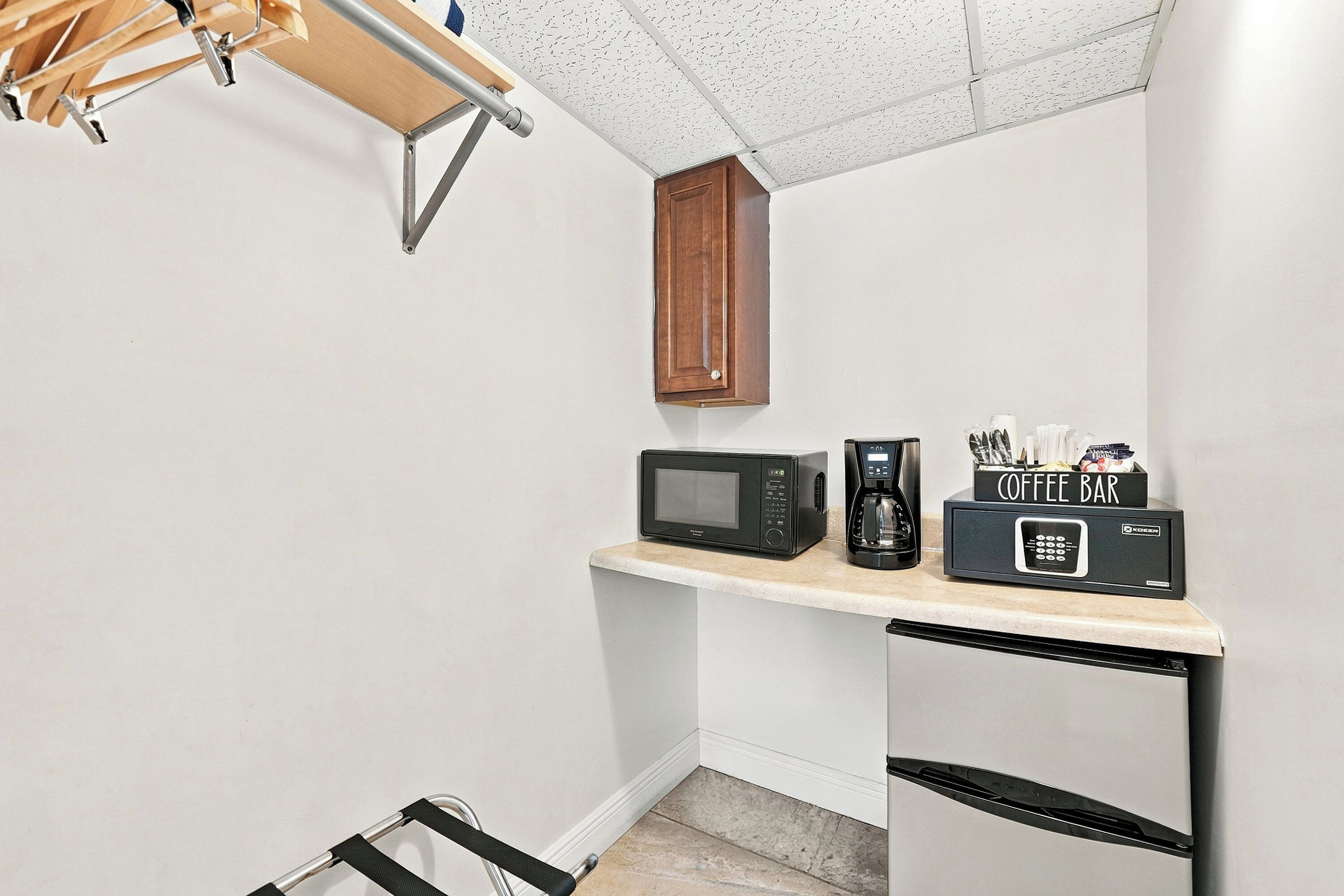 A compact kitchenette with a microwave, coffee maker, and a small refrigerator.
