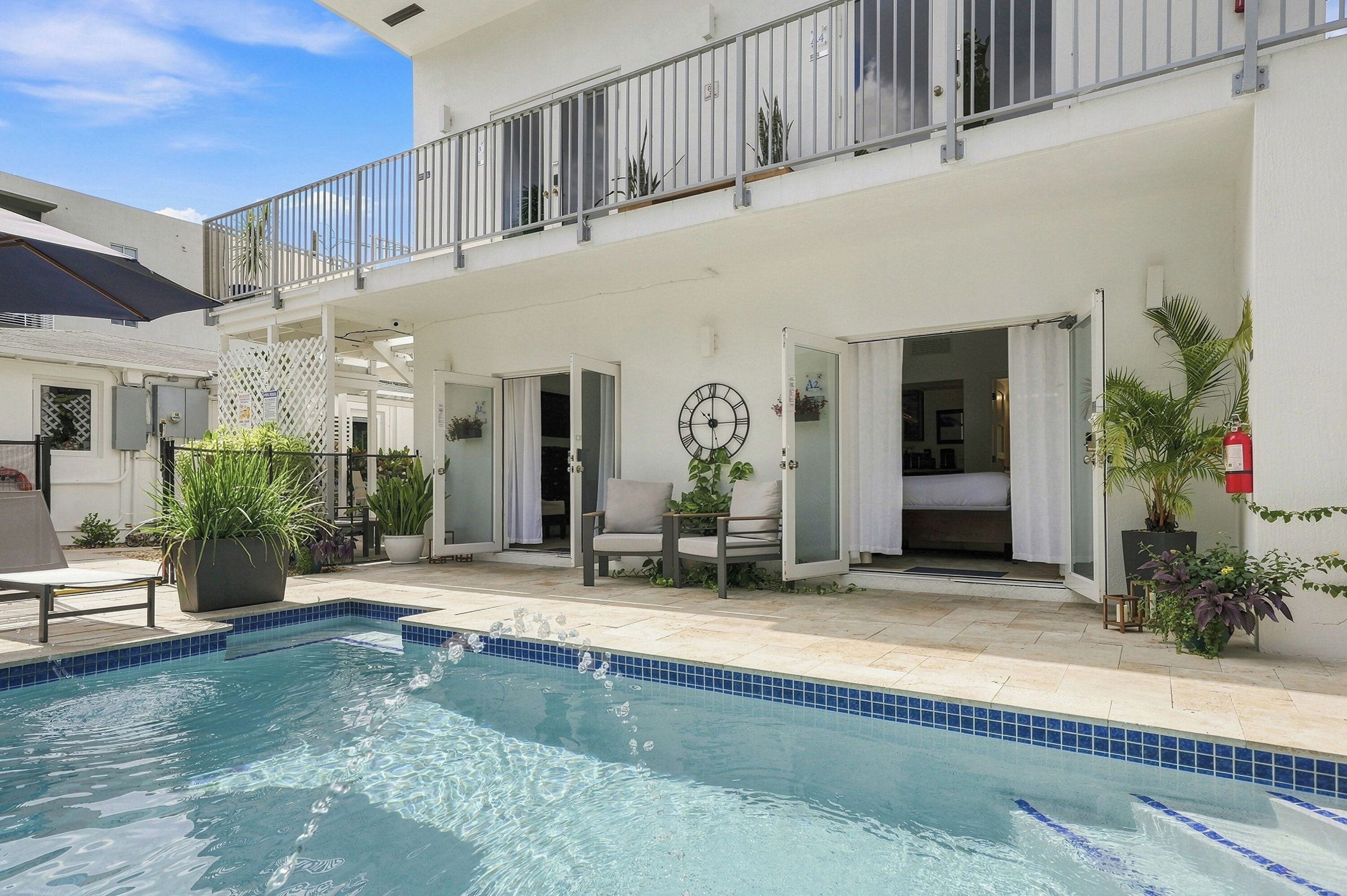 Ein Hotel mit Swimmingpool, Außenbereich und einem Balkon mit Geländer.