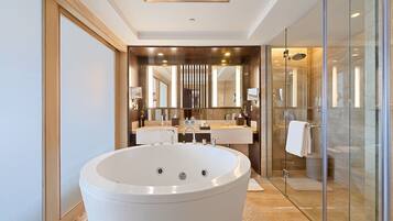 A modern bathroom with a freestanding bathtub, glass shower enclosure, and dual vanity sinks.
