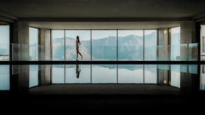 A spacious room with large windows offering a mountain view.