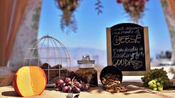 A table with a half-cut peach, grapes, nuts, and a chalkboard sign.