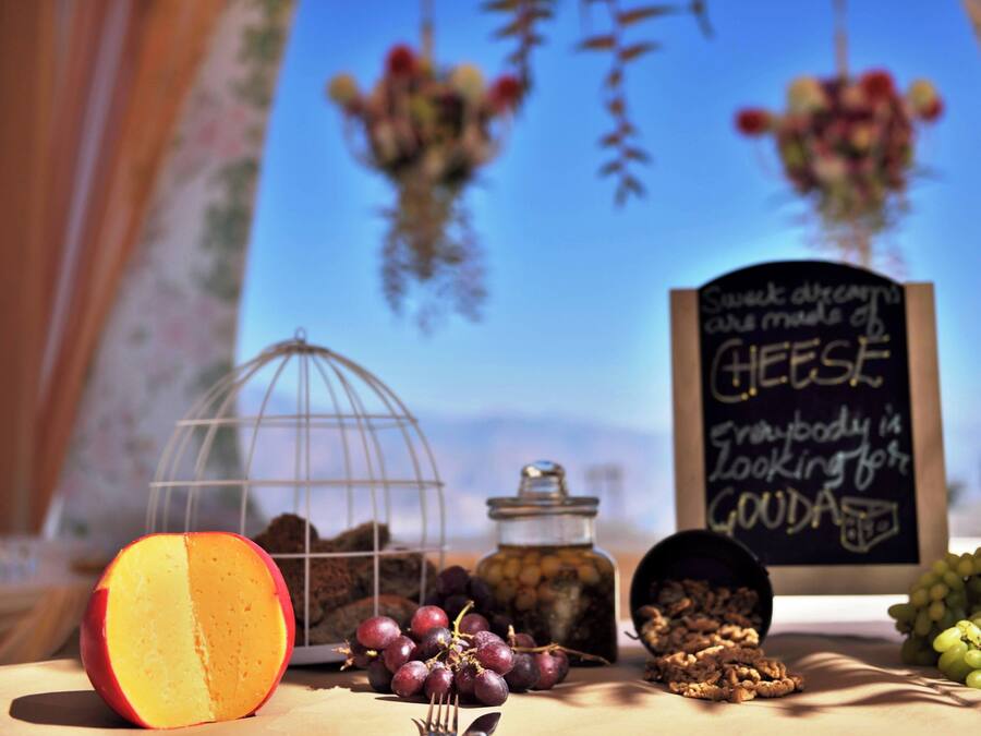A table with a half-cut peach, grapes, nuts, and a chalkboard sign.