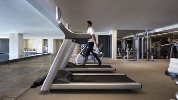 A modern gym with treadmills, weight machines, and a marble floor.