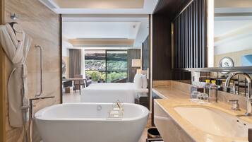 Un bagno moderno con una vasca freestanding, un ampio specchio e un lavandino.