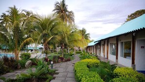 A resort with a pool, palm trees, and a covered walkway. - Atami Escape Resort (Tamanique)