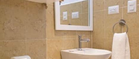 Ein Badezimmer mit Toilette, Waschbecken und Spiegel.