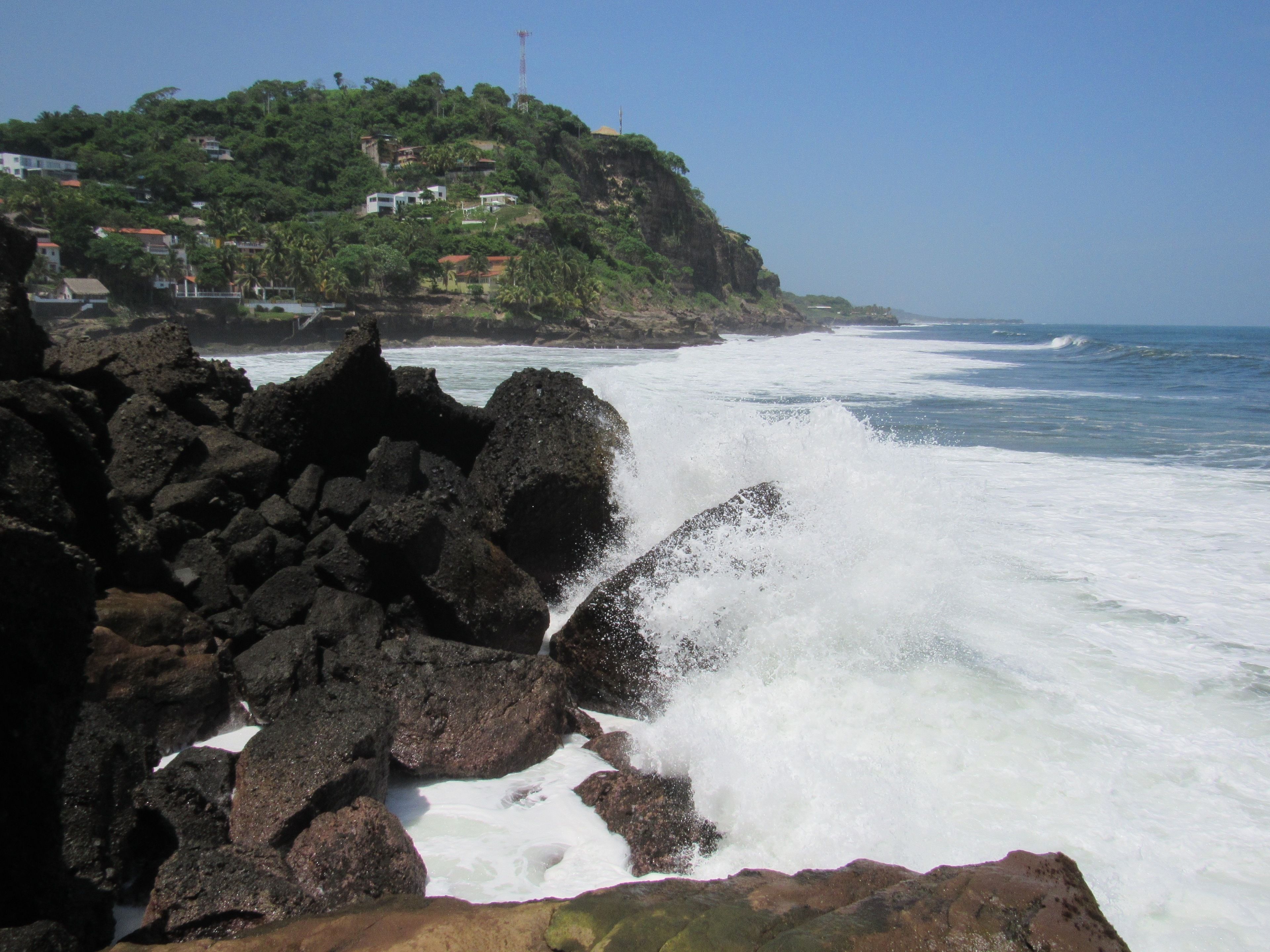 A rocky coastline with waves crashing against the rocks.