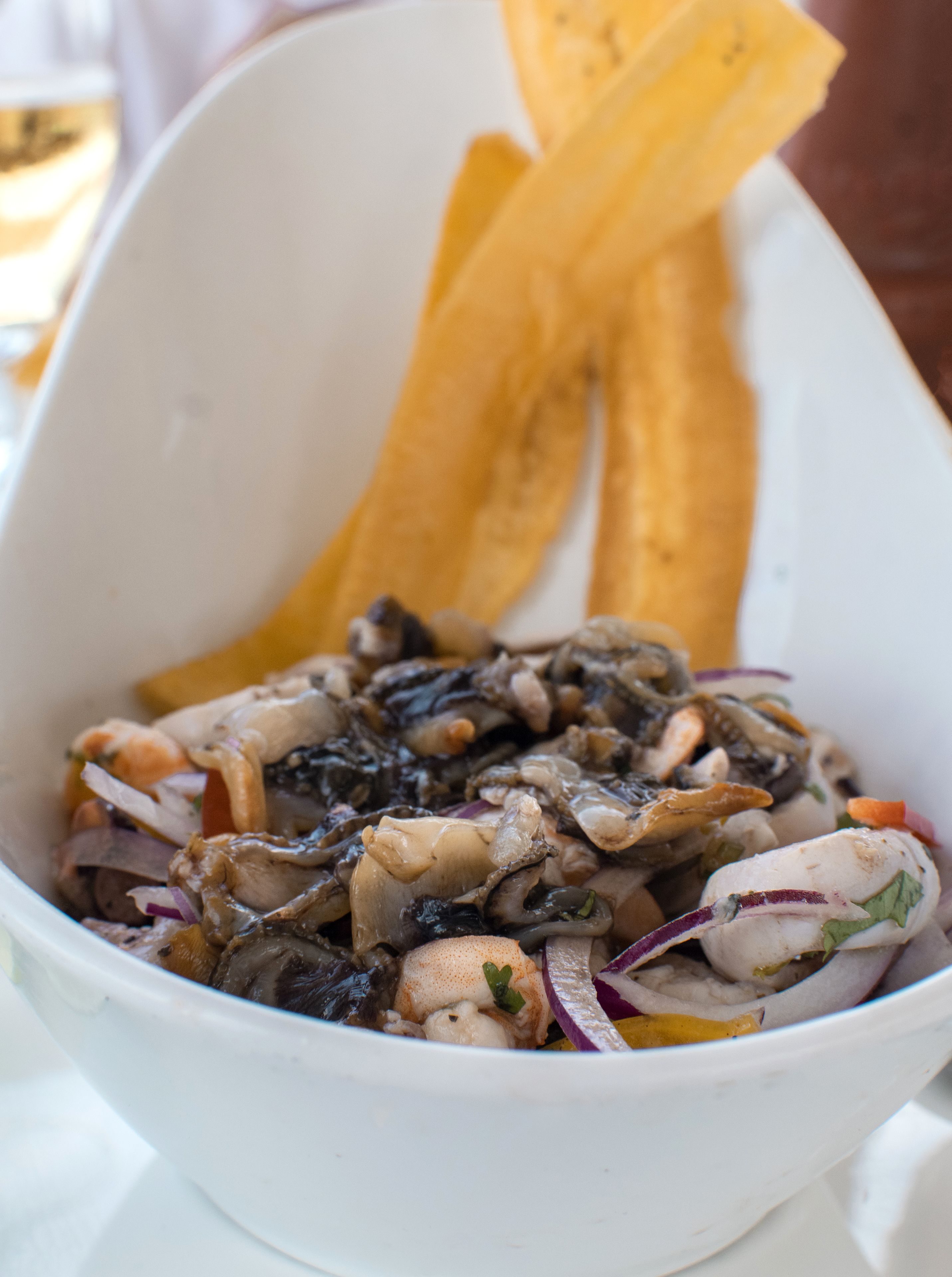 Un tazón de comida con diversos ingredientes, incluyendo mariscos y verduras.