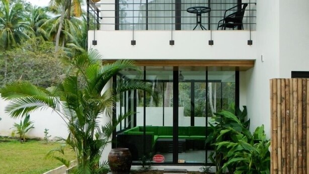 A modern two-story house with a balcony, large windows, and a green lawn. - Choeng Mon Gardens (Koh Samui)