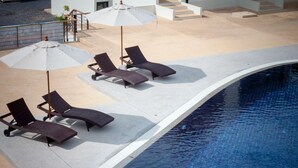 A poolside area with lounge chairs and umbrellas. - Choeng Mon Gardens (Koh Samui)