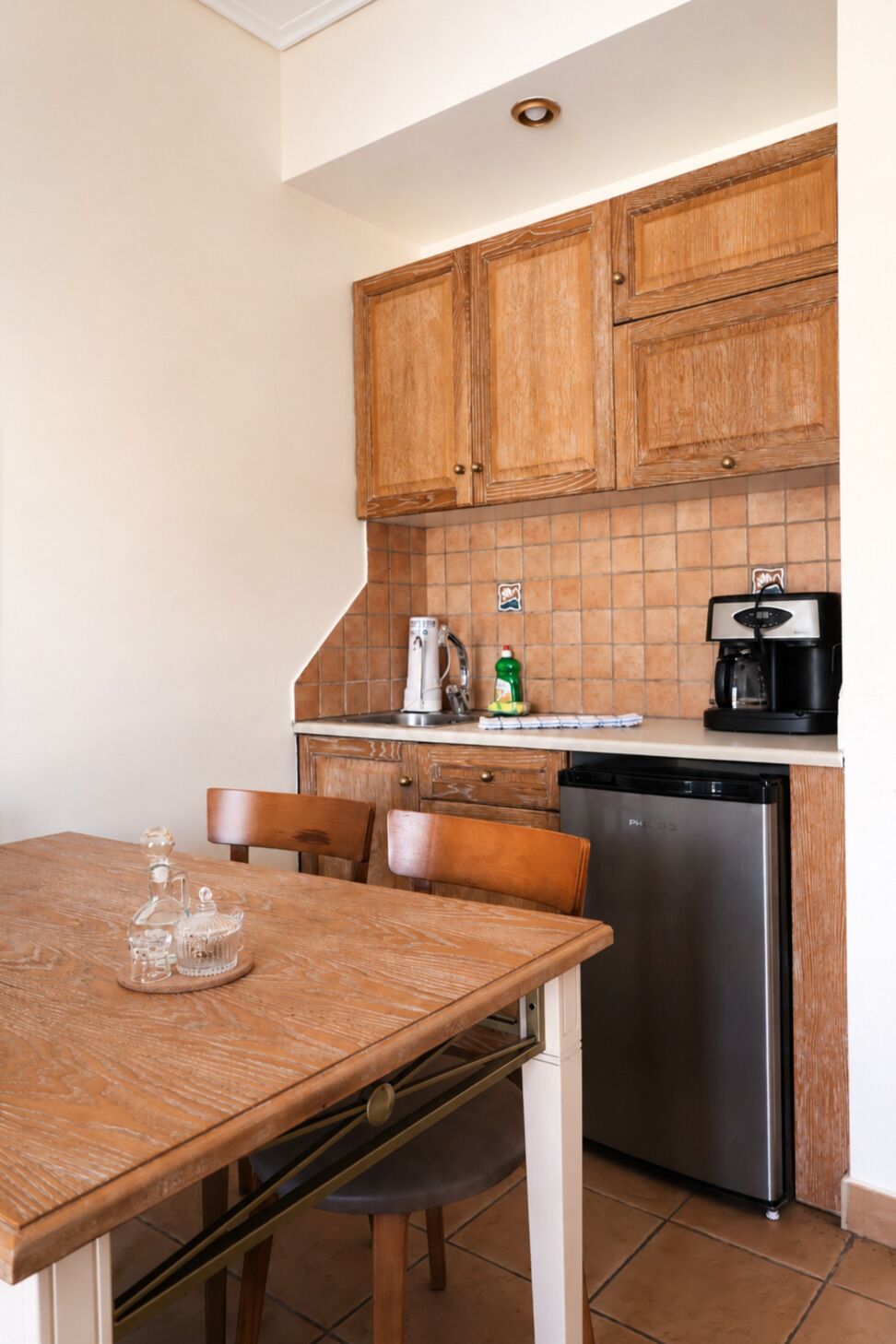 Una cocina funcional con armarios de madera, lavavajillas y cafetera.