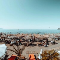 Una playa cerca, sillas reclinables de playa, sombrillas