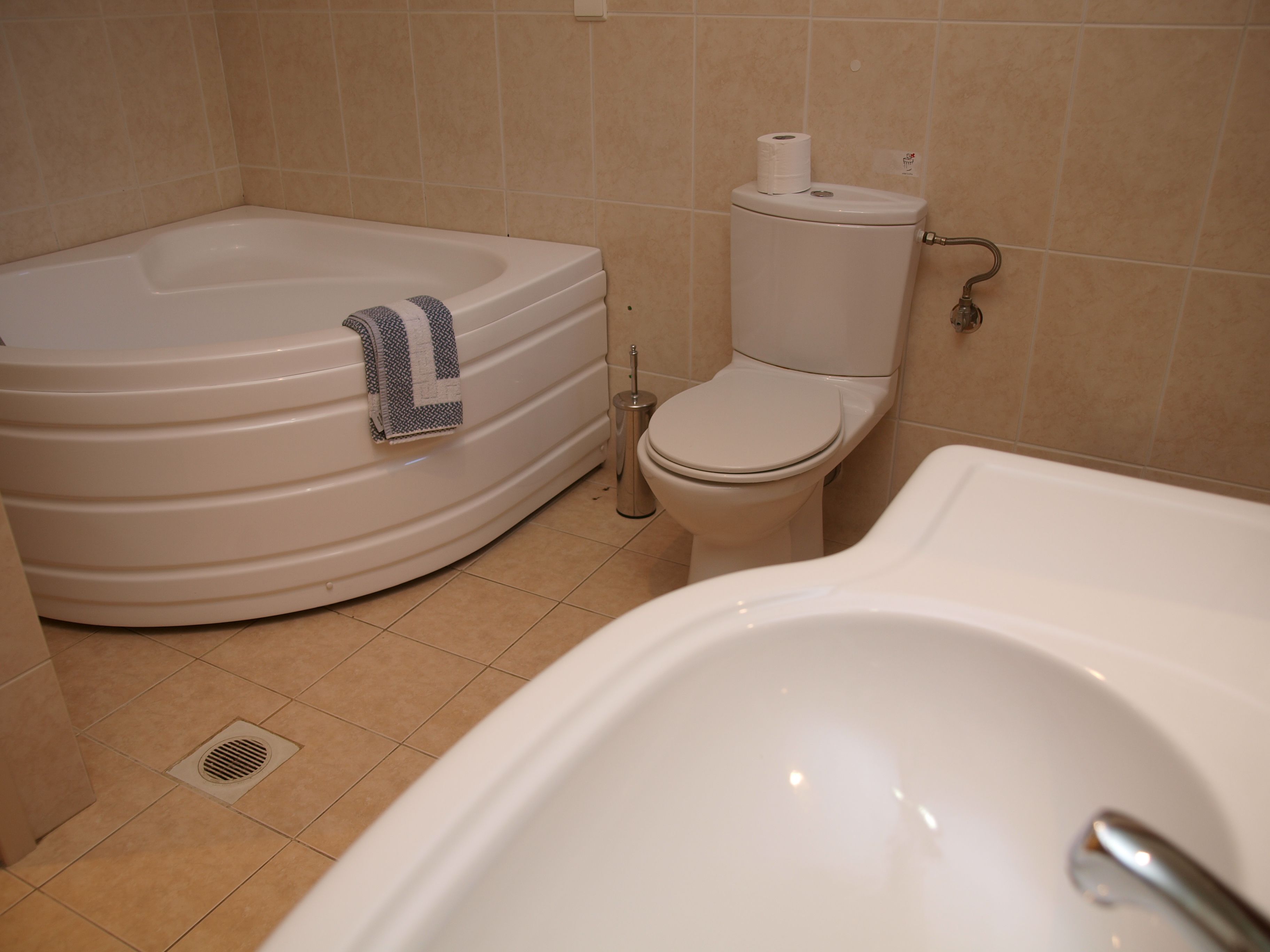 A bathroom with a bathtub, toilet, and sink.