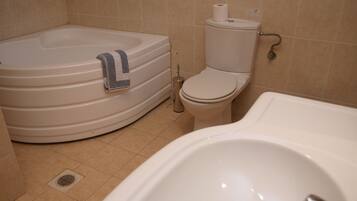 A bathroom with a bathtub, toilet, and sink.