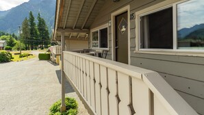 Un hôtel doté d’un porche abrité, d’une porte portant le numéro 15 et offrant une vue sur les montagnes en arrière-plan.