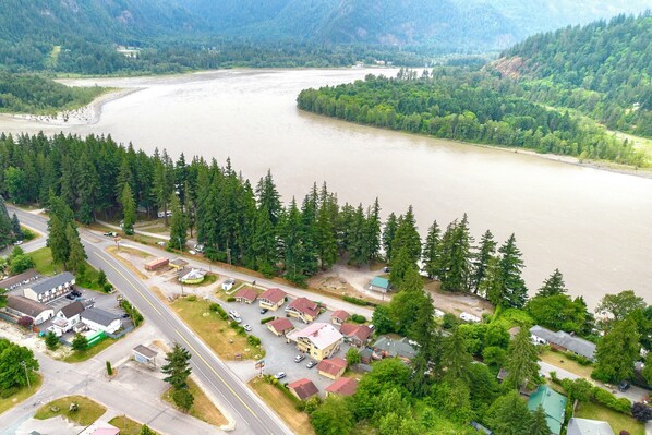 An aerial view of a residential area with houses, a road, and a river. - Richca Chalets Resort (Hope)