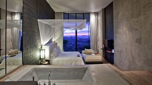 A modern bedroom with a large bed, a sitting area, and a bathtub. - Sala Khaoyai (Pak Chong)