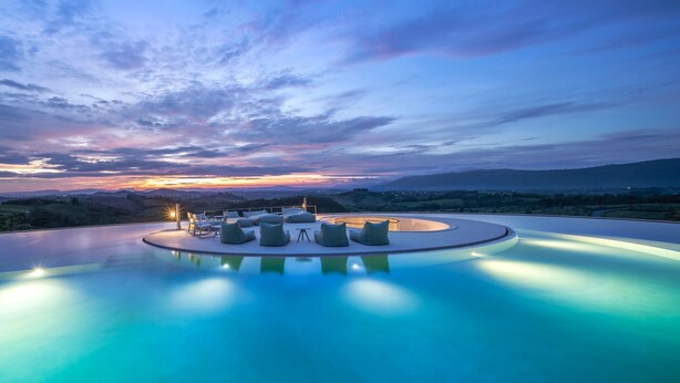 A infinity pool with seating and a sunset view. - Sala Khaoyai (Pak Chong)