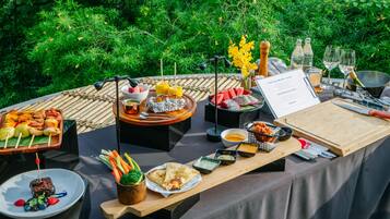An outdoor dining setup with various food items, a menu, and dining utensils.