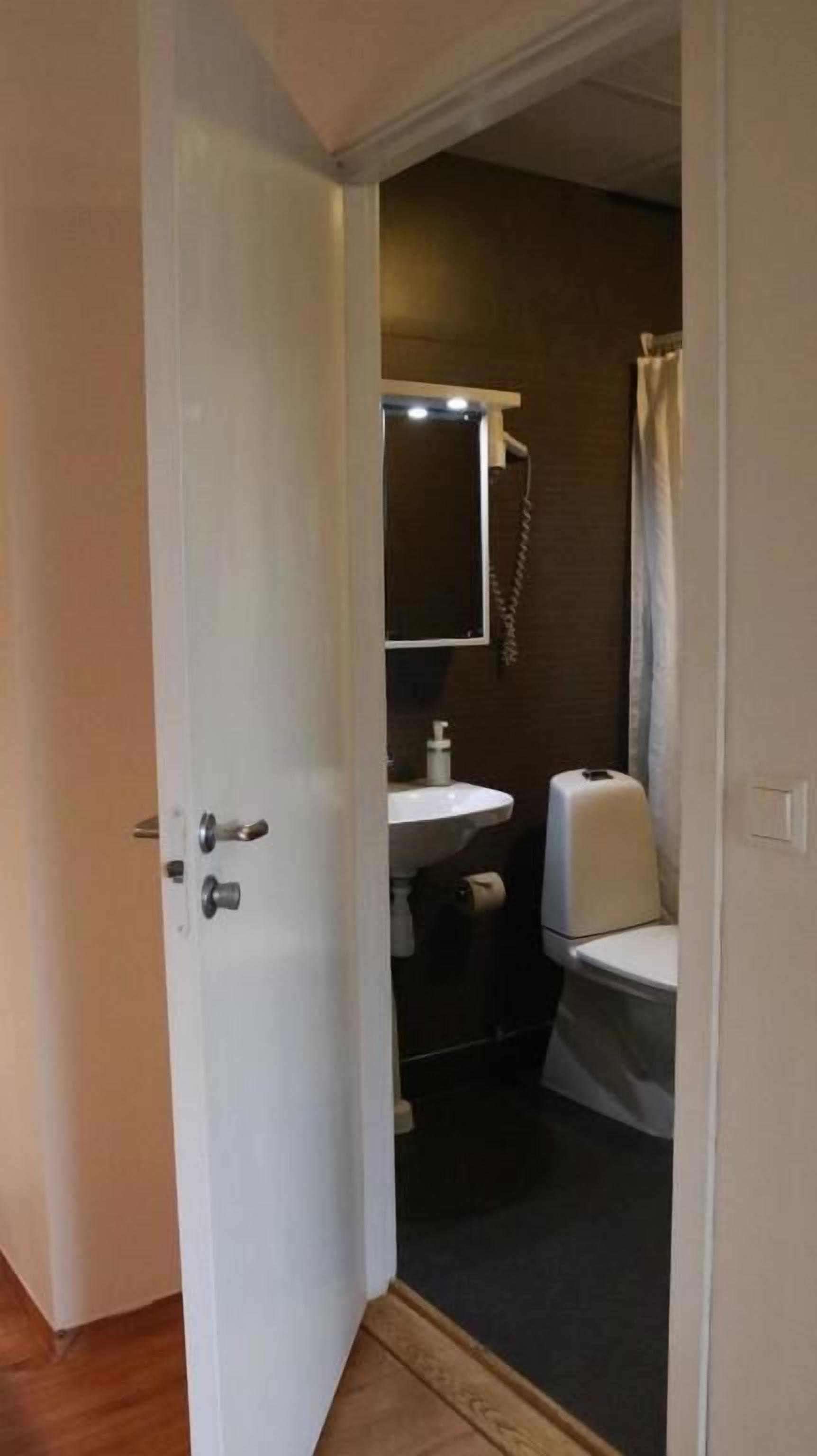 Un baño con inodoro, lavamanos y espejo.