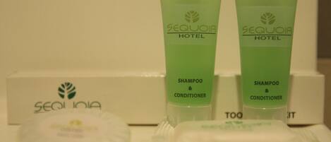 Toiletries including two green bottles labeled 'Sequoia Hotel Shampoo & Conditioner' and a white box with the same branding.