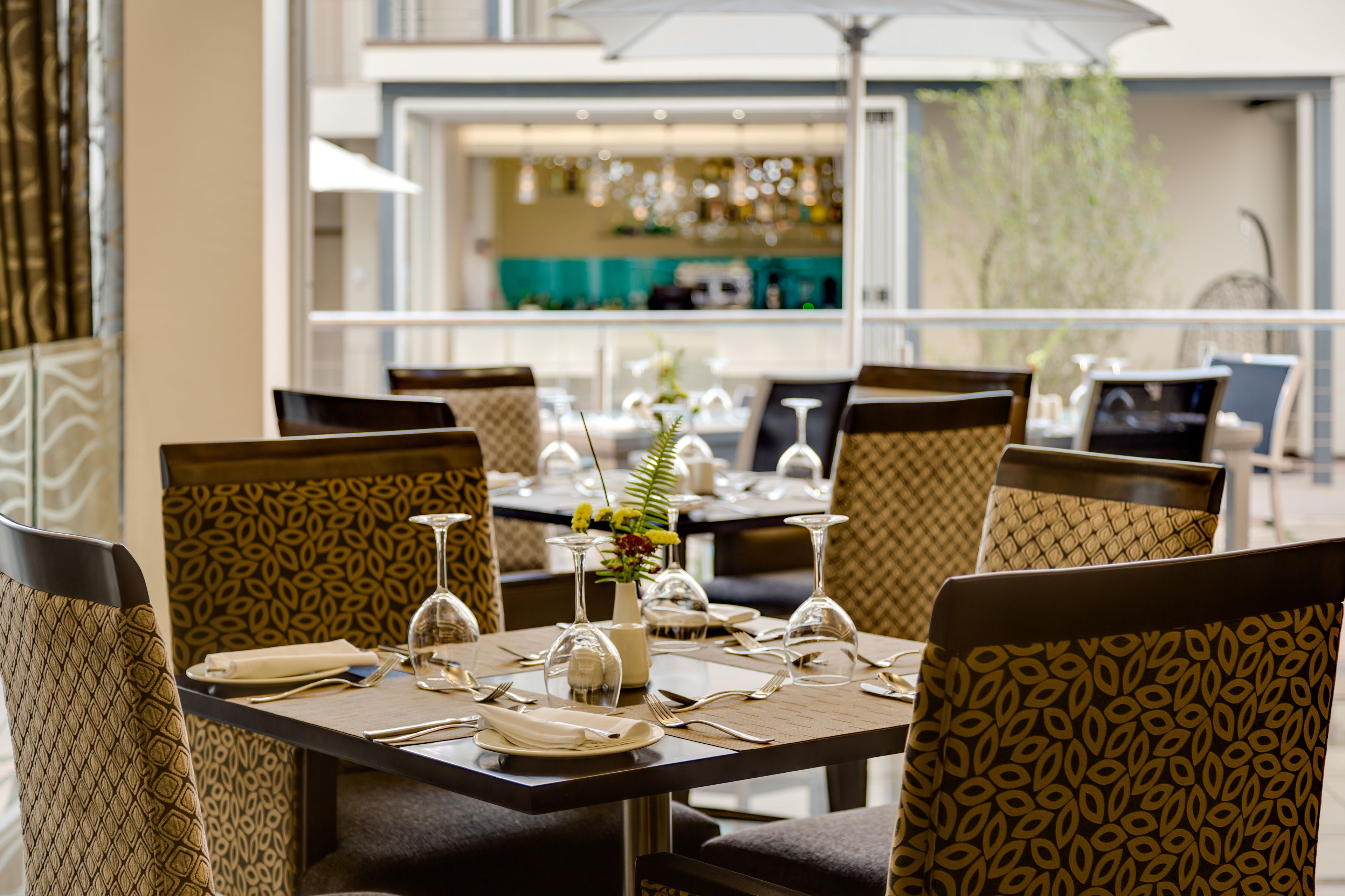 Un restaurante con una decoración moderna, con sillas y mesas estampadas dispuestas para comer.