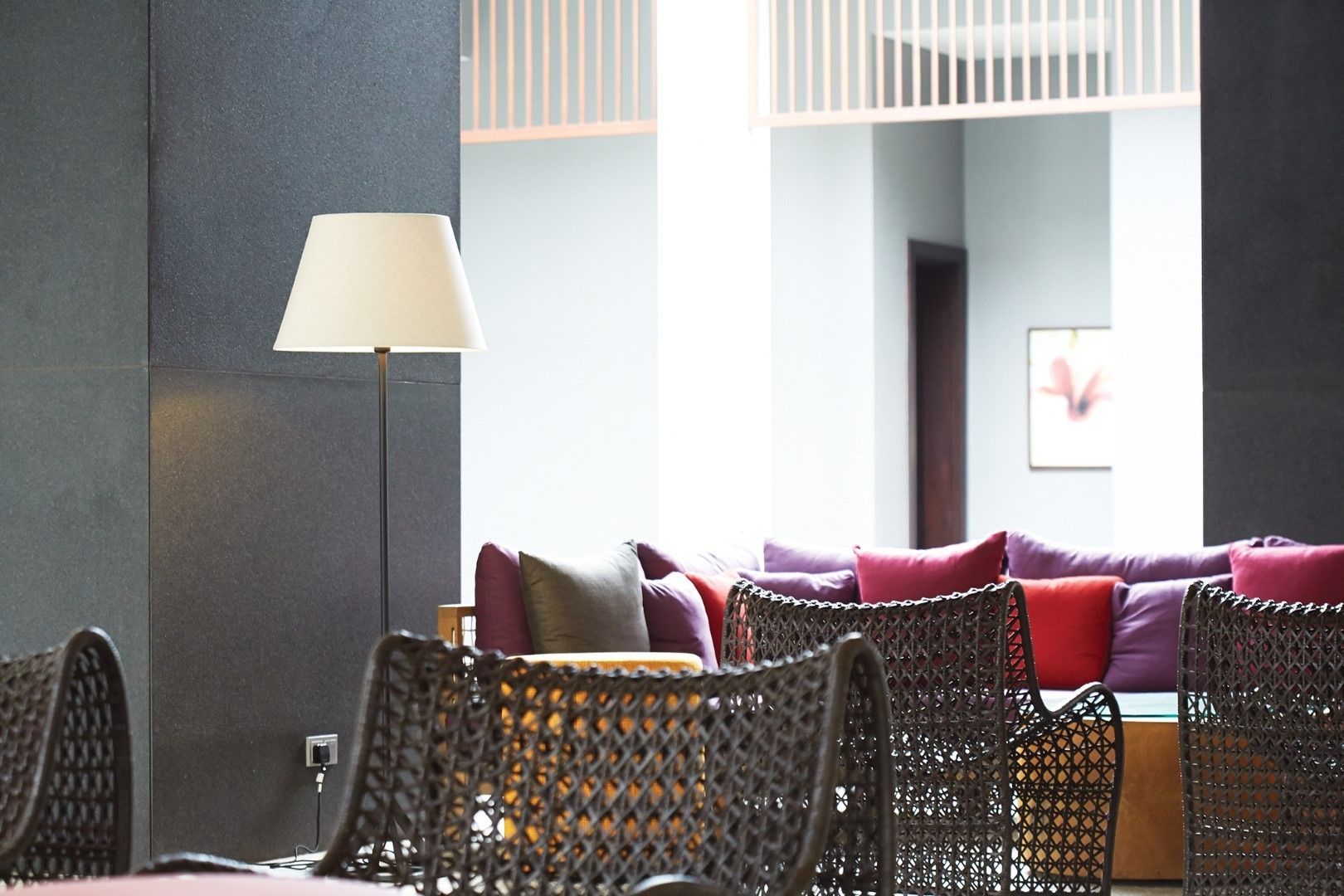 A modern interior with a sofa set, a floor lamp, and wicker chairs.
