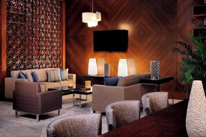 A modern living room with a wooden wall panel, a flat-screen TV, and a sofa set. - Residence Inn by Marriott Kuwait City (Kuwait City)